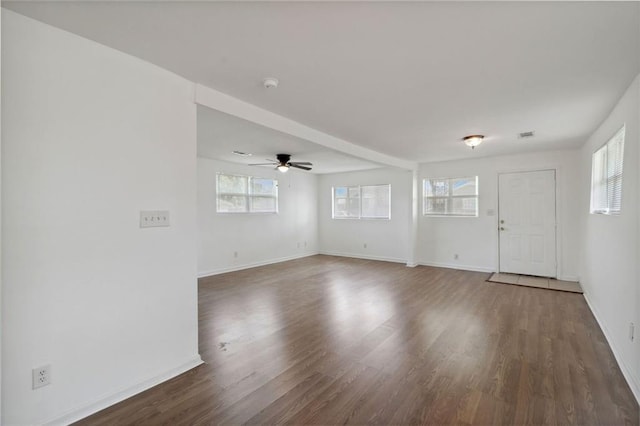 unfurnished living room with a wealth of natural light, dark hardwood / wood-style floors, and ceiling fan