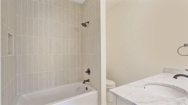 full bathroom with toilet, tiled shower / bath combo, and vanity