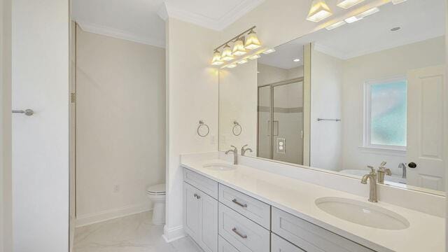 bathroom with a shower with door, vanity, ornamental molding, and toilet