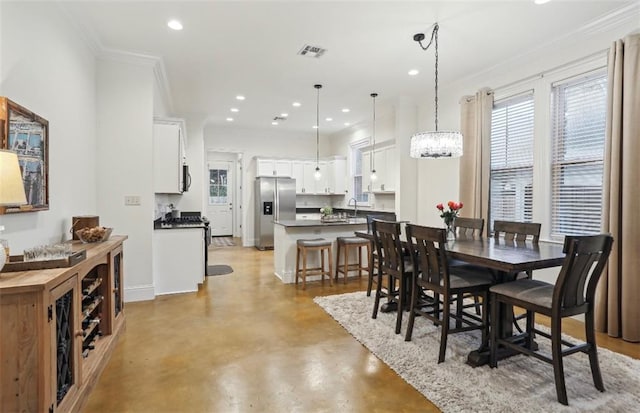 dining area featuring crown molding and a notable chandelier