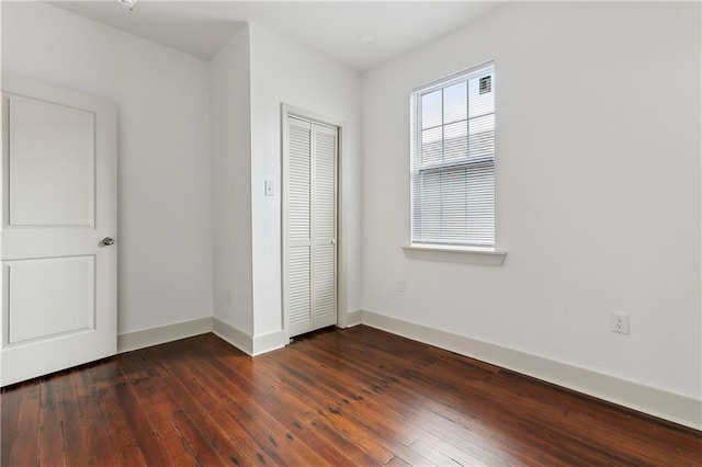 unfurnished bedroom featuring a closet and dark hardwood / wood-style flooring