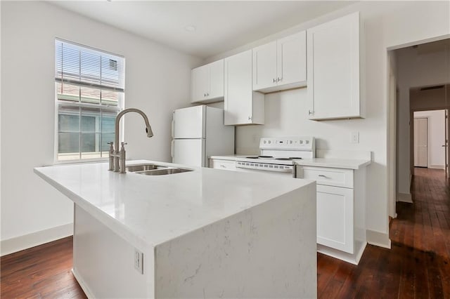 kitchen with white appliances, white cabinets, dark hardwood / wood-style floors, and a kitchen island with sink