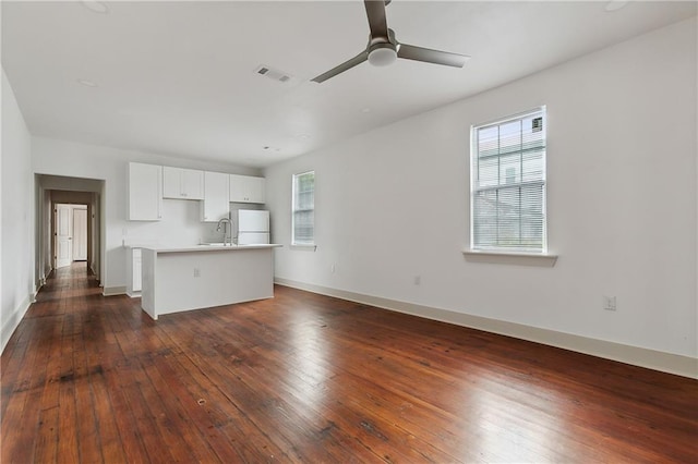 unfurnished living room with dark hardwood / wood-style floors and ceiling fan