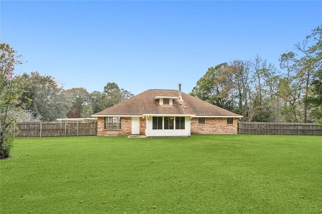 back of property featuring a lawn