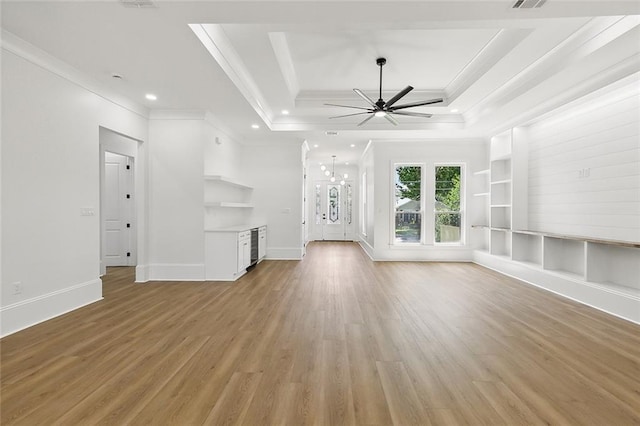 unfurnished living room with light wood-type flooring, ornamental molding, a tray ceiling, ceiling fan, and built in features