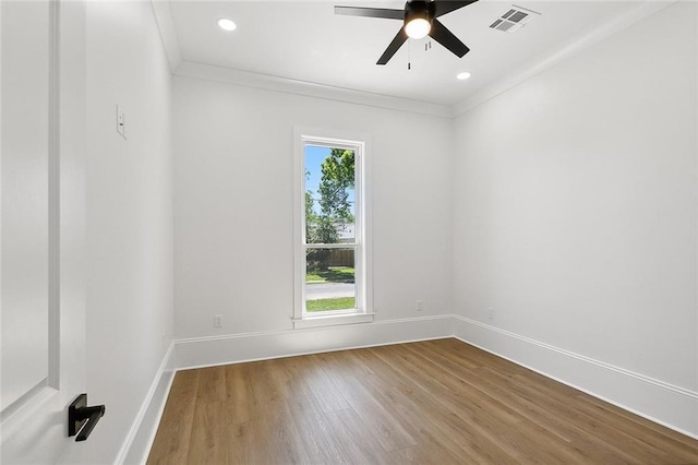 unfurnished room featuring hardwood / wood-style flooring, ceiling fan, and crown molding