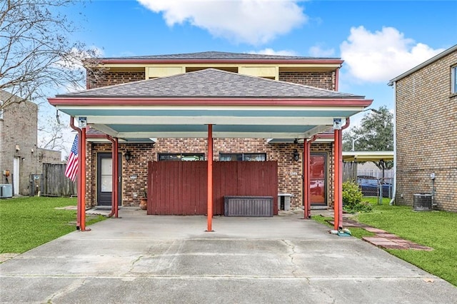 view of front of property featuring a carport, cooling unit, and a front yard