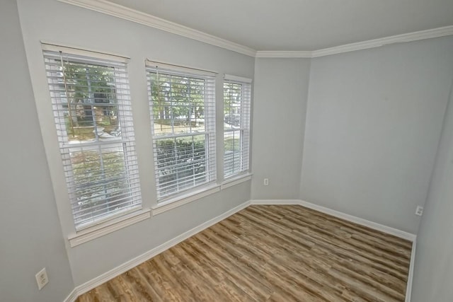 empty room featuring crown molding and wood-type flooring