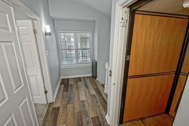 corridor featuring hardwood / wood-style flooring and lofted ceiling