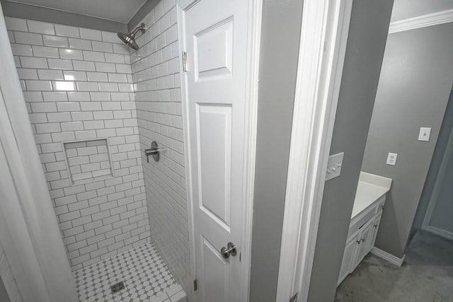 bathroom with a tile shower and vanity