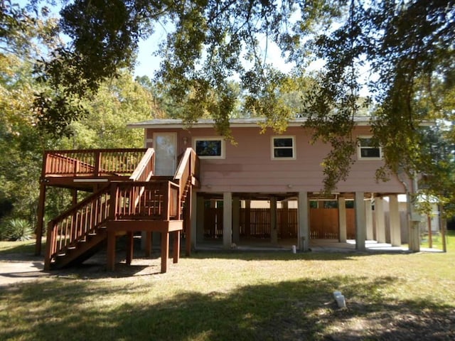 back of property featuring stairway, a lawn, and a wooden deck