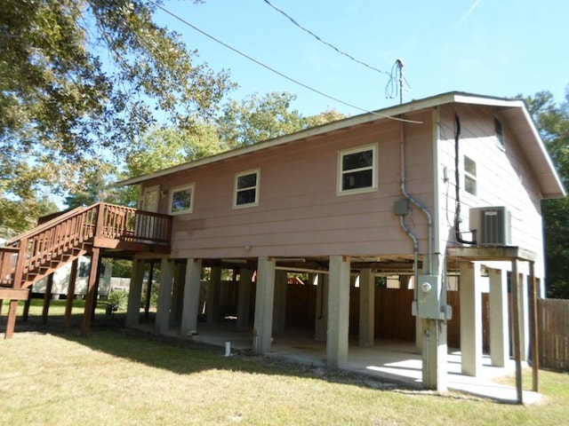 rear view of property featuring central AC, a yard, a deck, and a patio