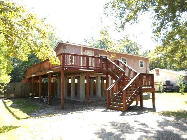 rear view of property with stairway, fence, and a wooden deck