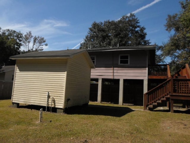 rear view of house with a deck and a lawn