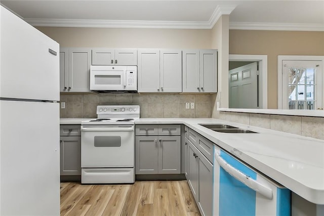 kitchen with white appliances, ornamental molding, light wood-type flooring, and gray cabinets