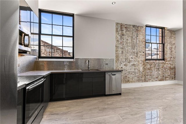 kitchen featuring stainless steel appliances, a healthy amount of sunlight, sink, and tasteful backsplash