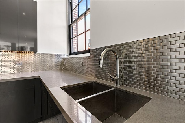 917 Conti St Unit 205, New Orleans, LA 70112 - kitchen featuring a sink, modern cabinets, dark cabinetry, and backsplash