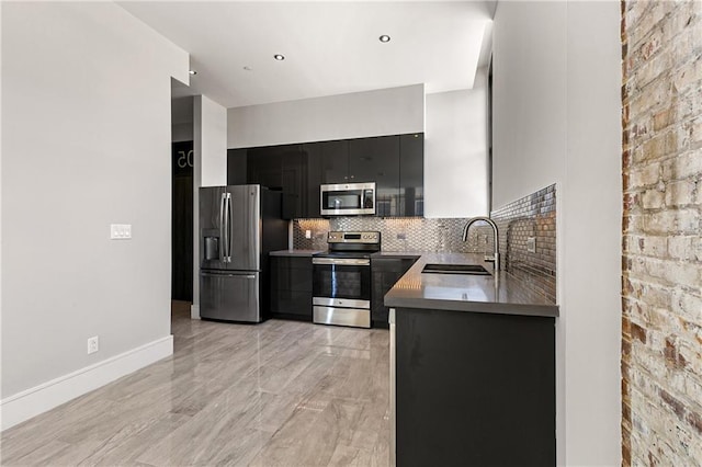 kitchen featuring decorative backsplash, stainless steel appliances, sink, and light hardwood / wood-style flooring