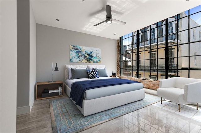 bedroom featuring hardwood / wood-style floors, ceiling fan, and multiple windows