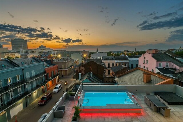 pool at dusk with a patio area