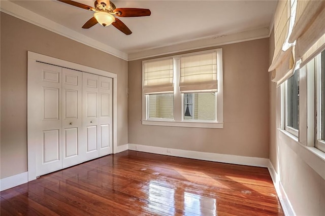 unfurnished bedroom with a closet, ceiling fan, ornamental molding, and dark hardwood / wood-style floors