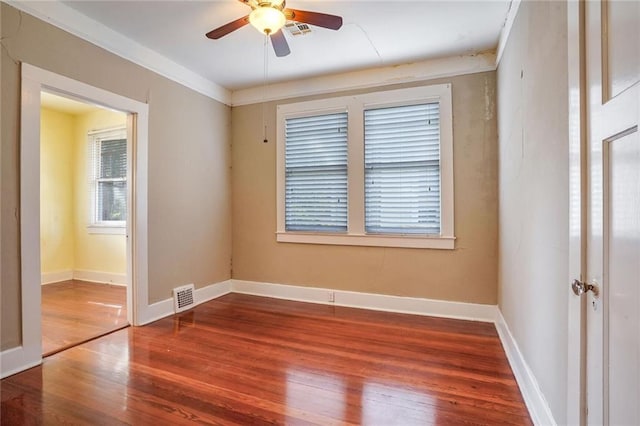 spare room with wood-type flooring, ceiling fan, and crown molding