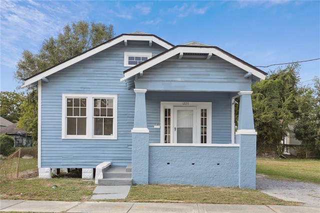 bungalow-style home with a front yard