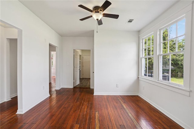 unfurnished room with a healthy amount of sunlight, ceiling fan, and dark hardwood / wood-style flooring