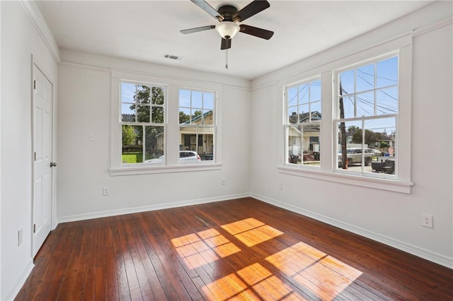 empty room featuring dark hardwood / wood-style flooring, ceiling fan, and a wealth of natural light