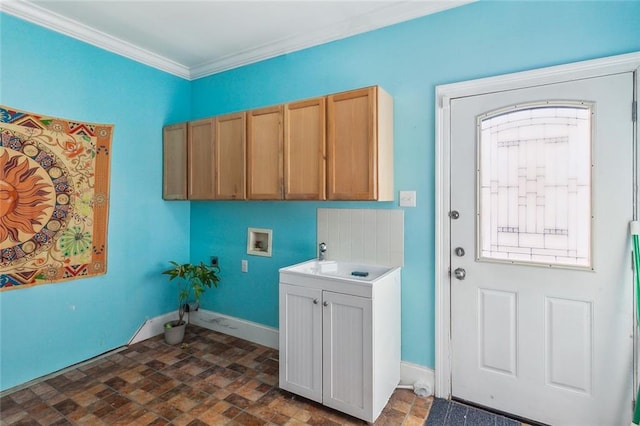 washroom with hookup for a washing machine, cabinet space, ornamental molding, a sink, and baseboards