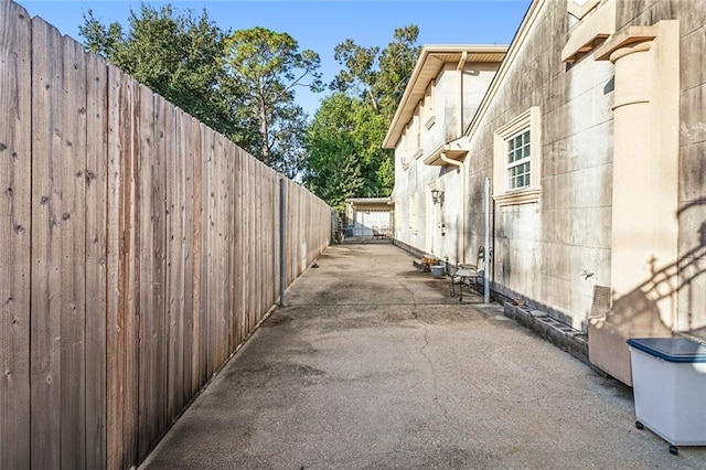 view of side of home with fence and a patio