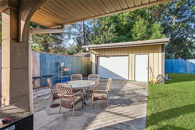 view of patio / terrace with an outbuilding, outdoor dining area, and a fenced backyard