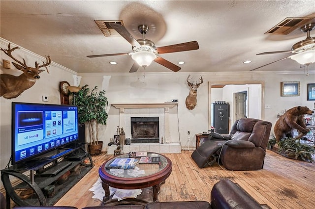 living room with ornamental molding, hardwood / wood-style flooring, and ceiling fan