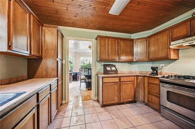 kitchen featuring wood ceiling, crown molding, light tile patterned flooring, tile counters, and stainless steel range with gas cooktop