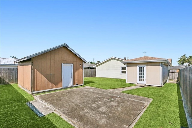 rear view of property featuring a lawn, a patio area, and a shed