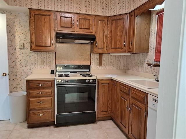 kitchen with white dishwasher, sink, black range oven, and light tile patterned flooring