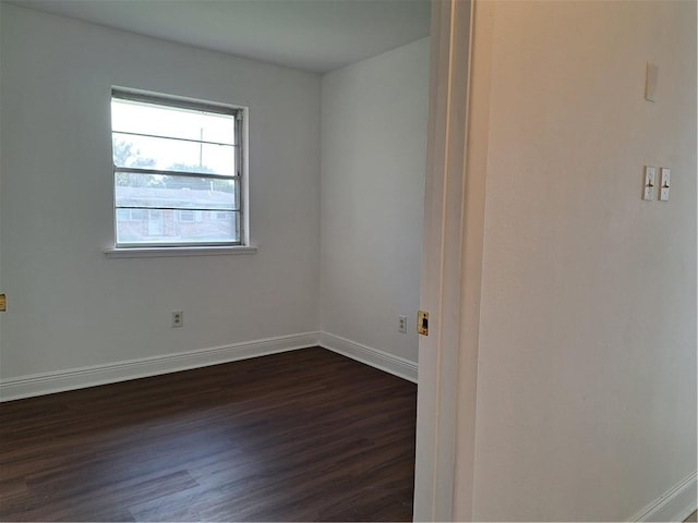 spare room featuring dark wood-type flooring