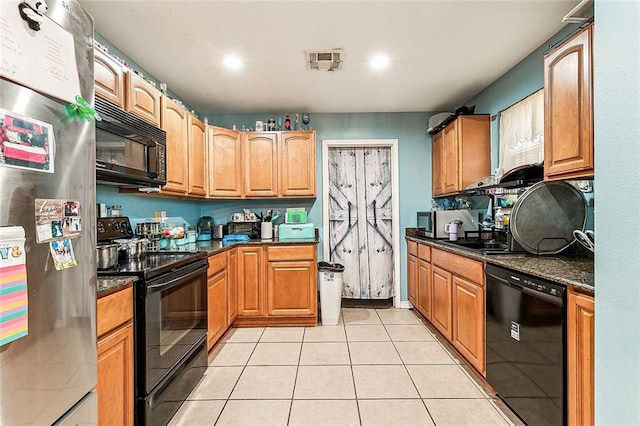 kitchen with light tile patterned floors, black appliances, and dark stone counters