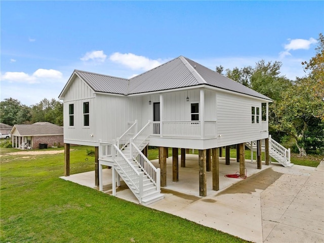 rear view of property with a lawn and covered porch