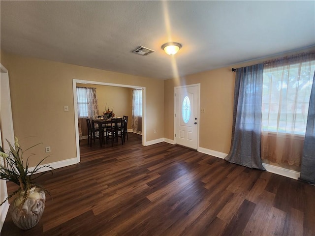 foyer with a healthy amount of sunlight and dark hardwood / wood-style flooring