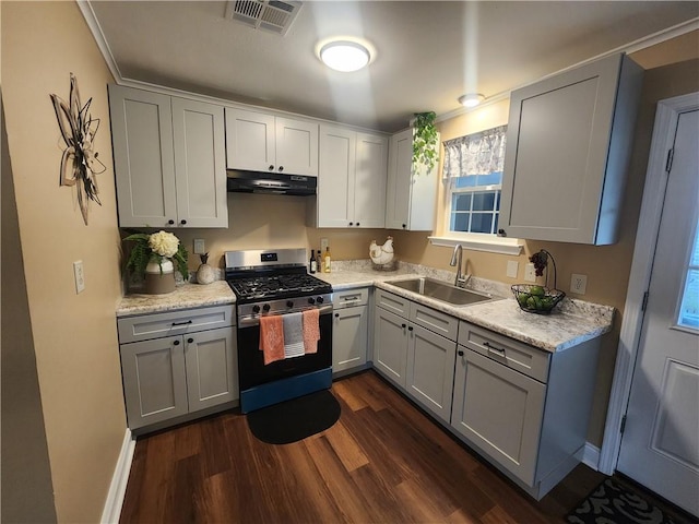 kitchen featuring gas stove, light stone countertops, dark wood-type flooring, gray cabinets, and sink