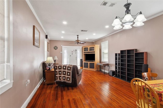 living room with crown molding, wood-type flooring, and ceiling fan with notable chandelier