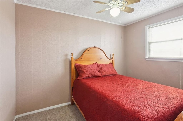 bedroom with ceiling fan, a textured ceiling, ornamental molding, and carpet floors