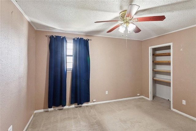 spare room featuring crown molding, light carpet, a textured ceiling, and ceiling fan