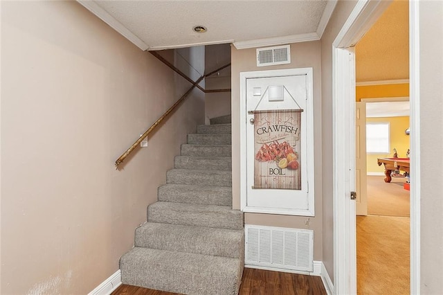 stairs featuring crown molding and wood-type flooring