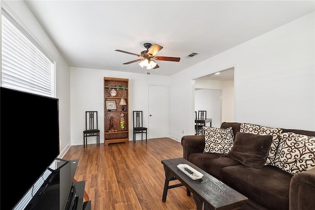 living room featuring wood-type flooring and ceiling fan