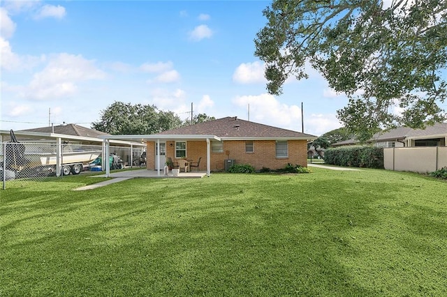 rear view of property with a lawn and a patio