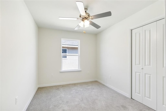 carpeted spare room featuring ceiling fan