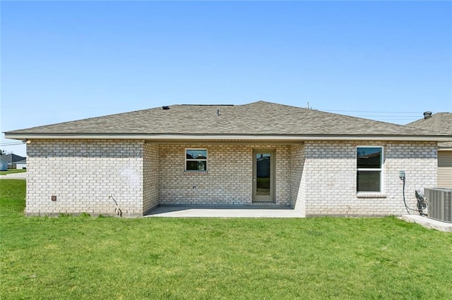 rear view of house with central AC and a lawn