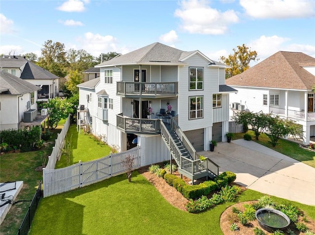 view of front of home with a front yard, a balcony, a garage, and central AC unit